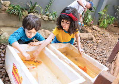 Two preschool students play with fish.